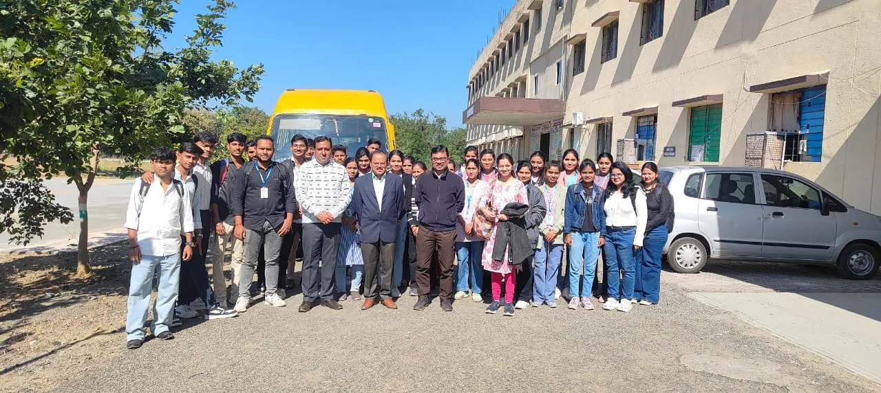 A group photo of MBA students and faculty members standing together on the college campus before leaving for the industrial visit